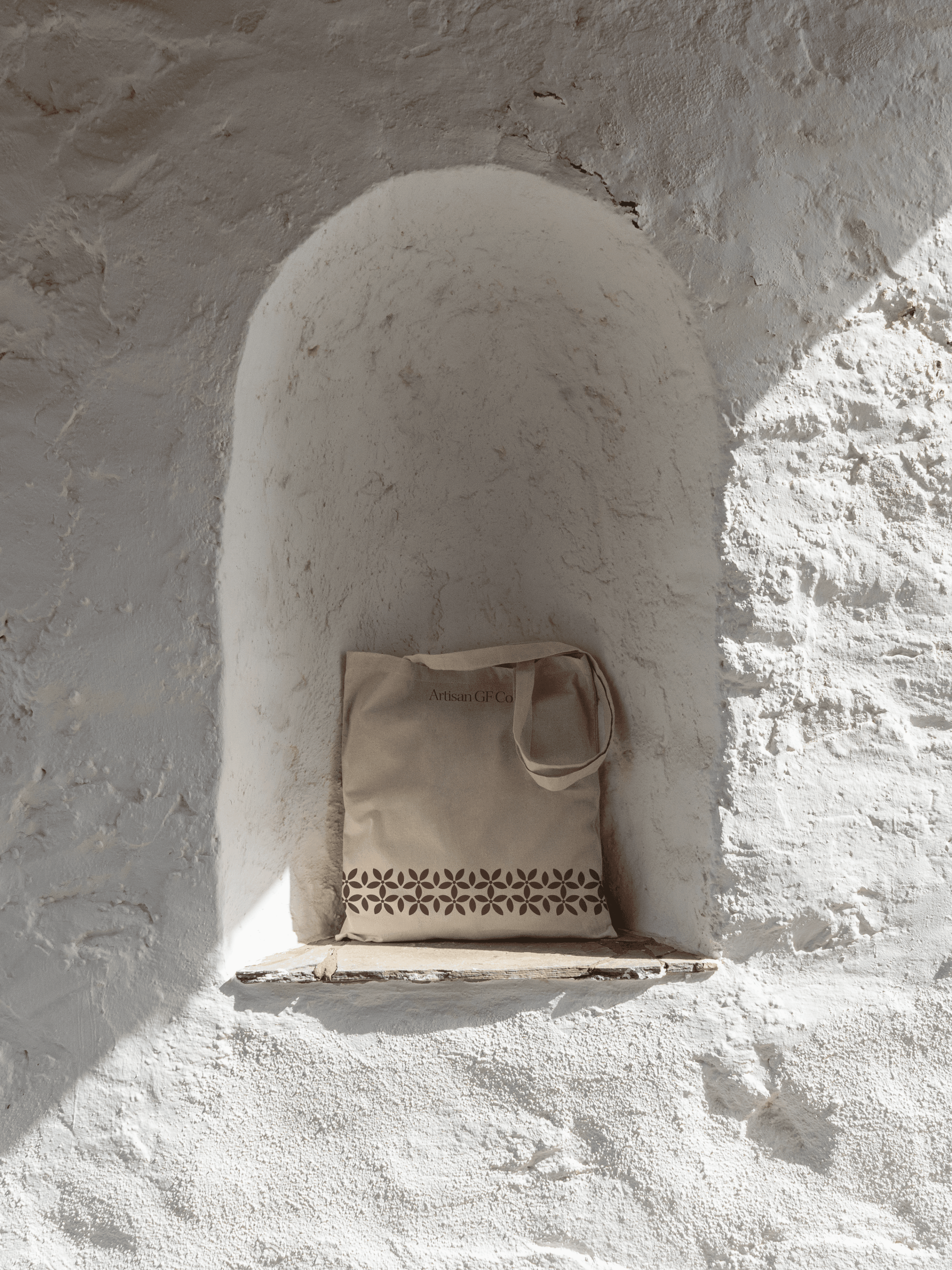 Artisan GF Co. tote bag resting in an arched niche in a whitewashed wall