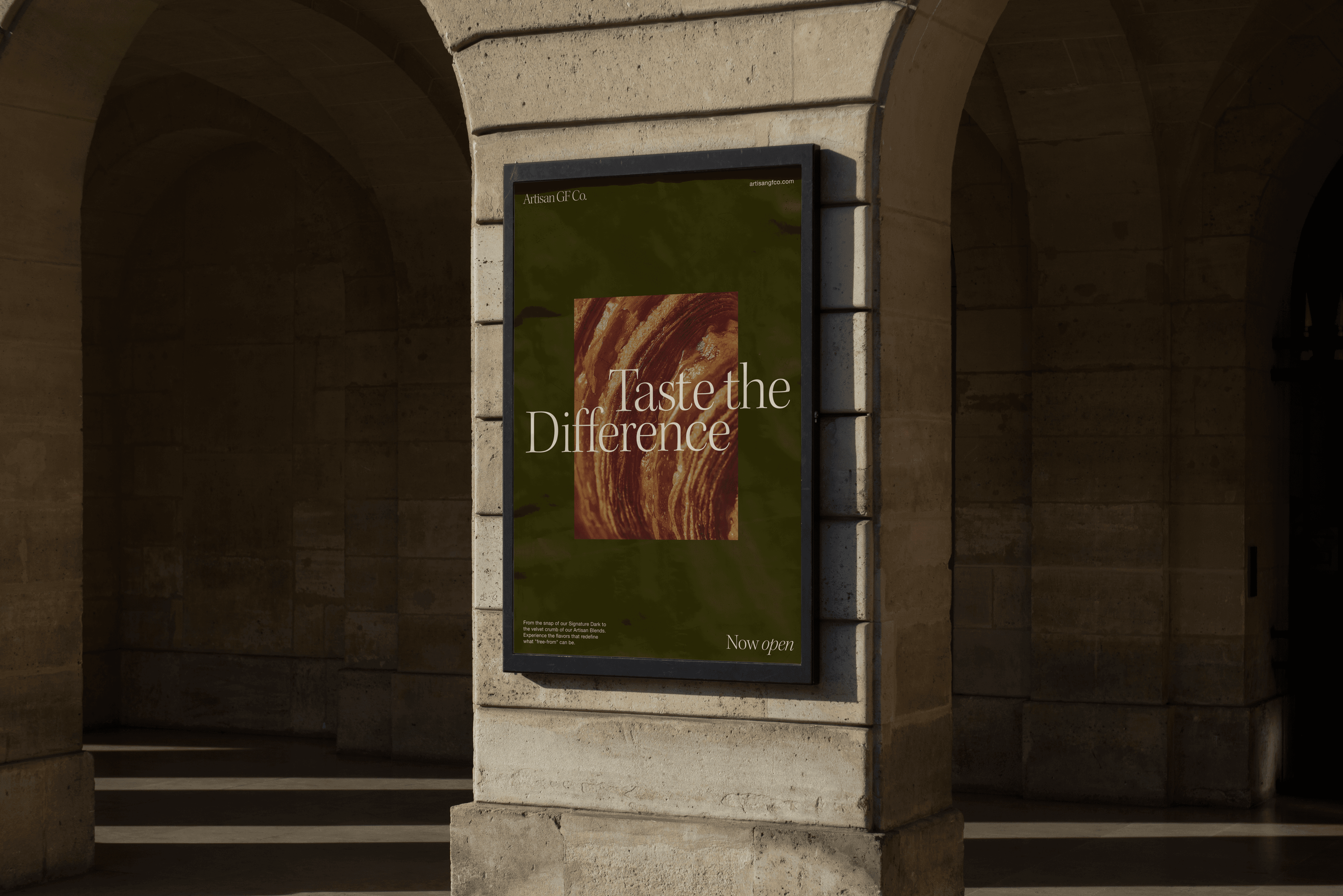 Artisan GF Co. poster in a street display case under a sandstone arch