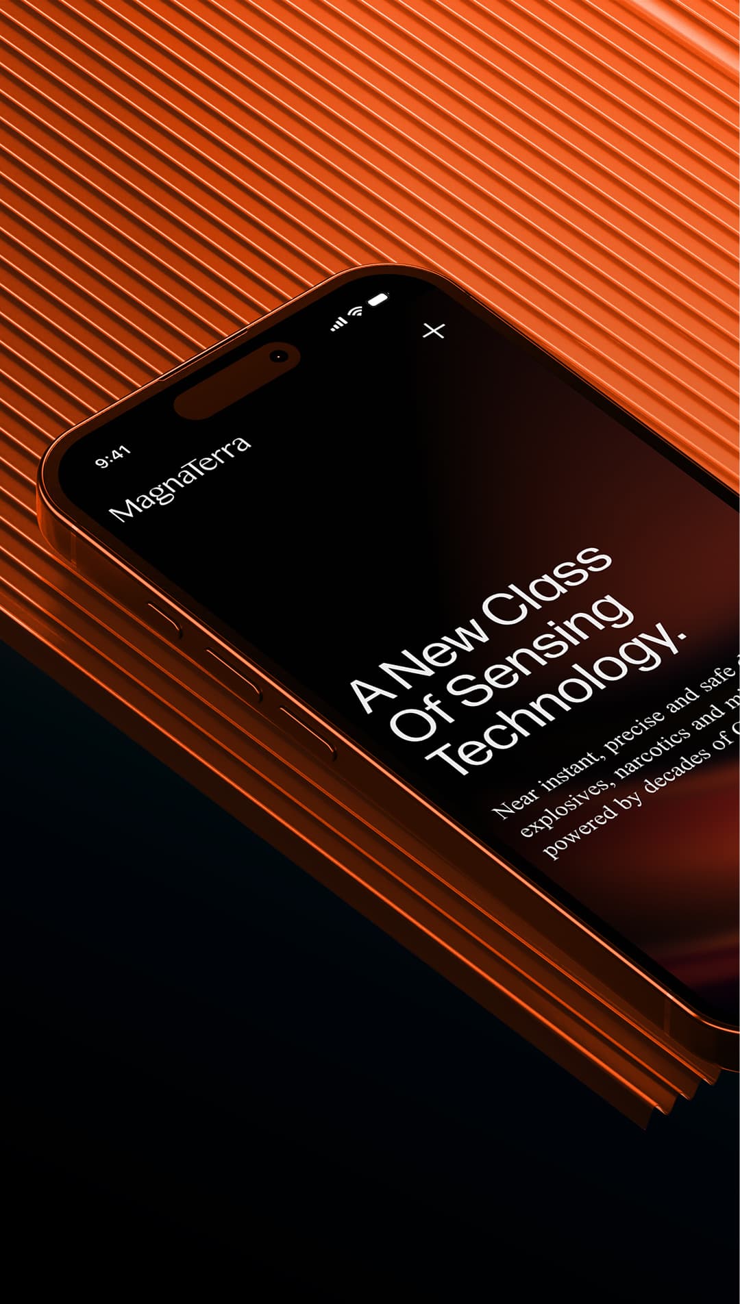 The MagnaTerra Technologies website on a mobile phone, angled on a ribbed orange surface